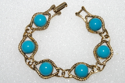 +MBA #E56-075   "Older Antiqued Goldtone Blue Acrylic Stone Bracelet"